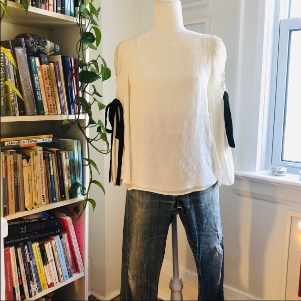 White blouse with black bows and bell sleeves